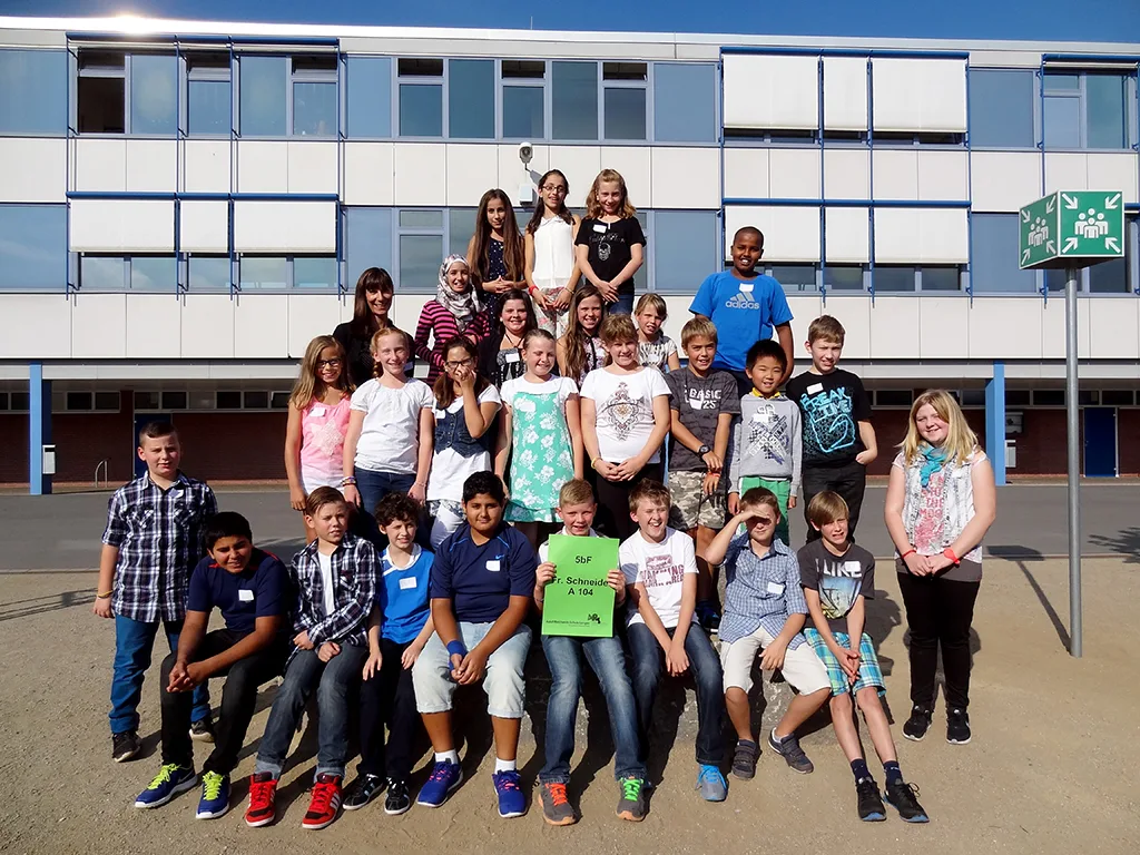 Klassenfoto einer neuen fünften Klasse vor dem Gebäude.